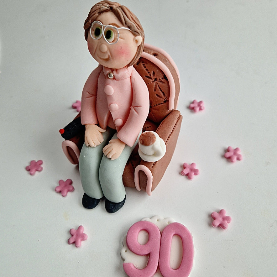 Edible fondant figurine sitting in the armchair cake decoration