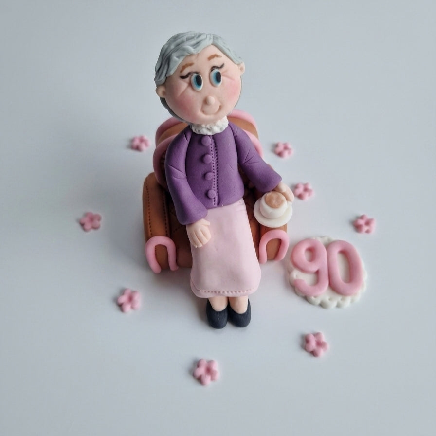 Edible fondant figurine sitting in the armchair cake decoration